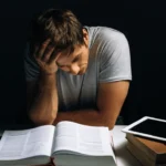 A man siting on a desk and learning how to study in a distracting environment