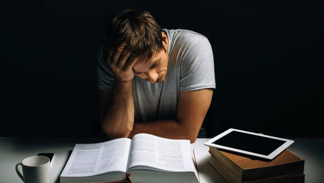 A man siting on a desk and learning how to study in a distracting environment